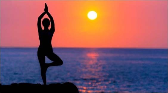 silhouette of person doing yoga pose on beach